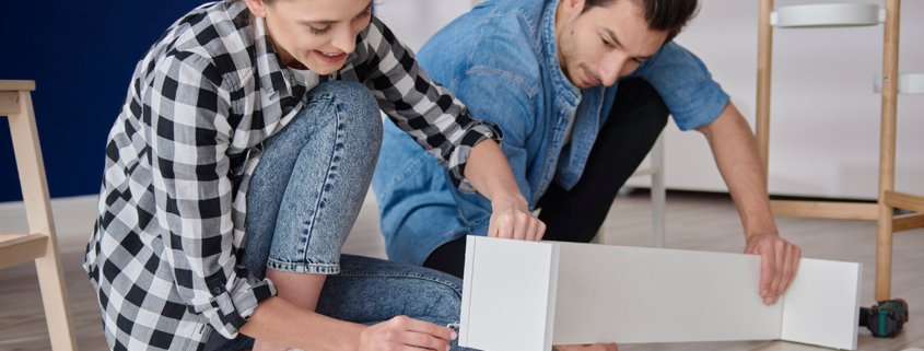 couple installing bookshelf for new house stock photo